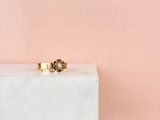 une bague en or posée sur un bloc de marbre blanc