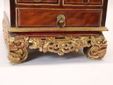 a small chest of drawers with a clock on top of it