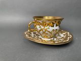 a close up of a cup and saucer on a table