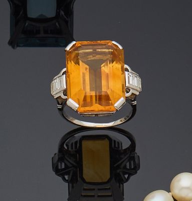 une bague avec une pierre orange entourée de perles