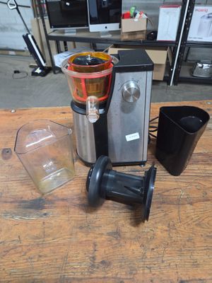 a blender sitting on top of a wooden table next to a cup