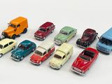 several toy cars are lined up in a row on a white surface