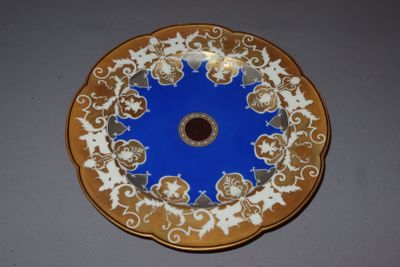 a blue and gold plate with a flower design on it