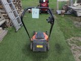 une tondeuse à gazon posée sur l'herbe dans le jardin