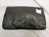 black leather clutch bag on white bed with white sheets
