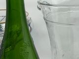 a green glass vase and a green glass pitcher on a table