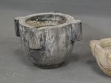 two stone bowls sitting next to each other on a table