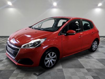 a red car is parked in a room with a checkered floor
