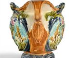 a vase that has a bird on it on a stand