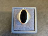 un gros plan d'une bague en argent sertie d'une pierre noire