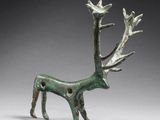 a close up of a bronze statue of a deer with birds on it