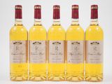quatre bouteilles de vin posées les unes à côté des autres sur une surface blanche