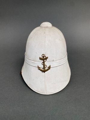 un vieux casque blanc orné d'une ancre dorée
