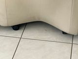 a white couch that is sitting on a tile floor