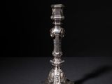 an antique silver candle holder on a black background