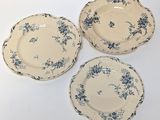 three blue and white plates with flowers on them on a white surface