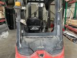 a forklift in a warehouse with lots of shelves and pallets in the background