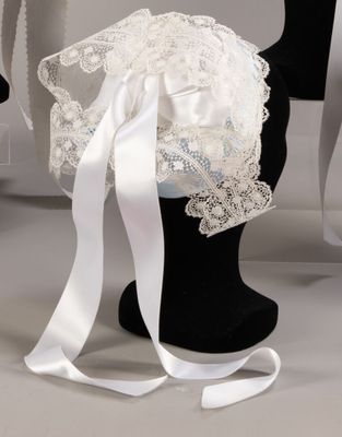 a mannequin with a veil and a white ribbon on it