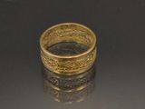 une bague en or posée sur une surface noire