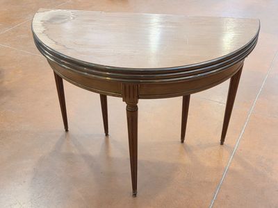 TABLE DEMI-LUNE en bois reposant sur pieds cannelés.