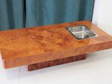 une table en bois sur laquelle se trouve un évier, devant un rideau