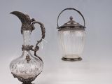 deux vases en argent et en verre posés sur une surface blanche