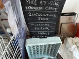a chalk board with a menu on it next to a dishwasher and a dishwasher