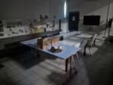 a room with a table, chairs, and a television in it