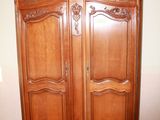 a large wooden armoire in the corner of a room