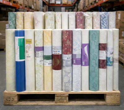 many rolls of fabric on a pallet in a warehouse