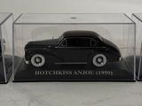 a black toy car in a clear case on a table