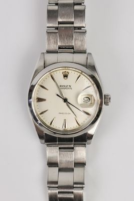 un gros plan d'une montre sur une surface blanche avec un fond blanc