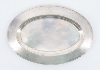 a silver plate on a white table with a white background