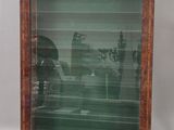 an old picture of a man and a woman sitting at a table in a glass case