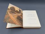 an open book with a picture of a house in the background