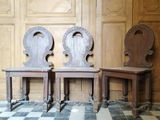 deux chaises en bois placées l'une à côté de l'autre sur un sol à carreaux