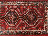 un gros plan sur un tapis rouge orné de deux médaillons