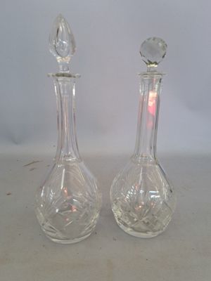 two clear glass vases sitting next to each other on a table