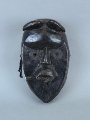 une image représentant un masque noir accroché à un mur