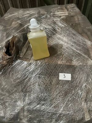 a bottle of liquid sitting on a table covered in plastic