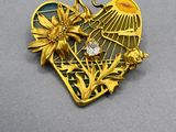 a close up of a heart shaped pendant with flowers on it