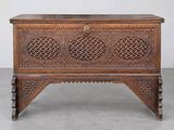 an old wooden chest with intricate carvings on the sides