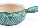 a green cup with a spoon sticking out of it