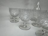 six wine glasses lined up on a white table