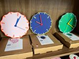 three clocks sitting on a shelf in a store
