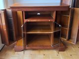 une armoire en bois dont la porte est ouverte, posée sur un parquet en bois massif