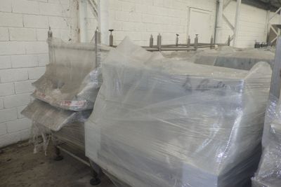 un gros tas de meubles emballés dans du plastique dans un entrepôt