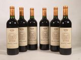 quatre bouteilles de vin sont alignées sur une surface blanche