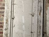 an old door that is leaning against a brick wall
