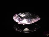 gros plan d'un diamant rose sur une surface noire